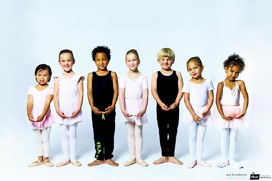 zeven kinderen op een rij in balletpositie