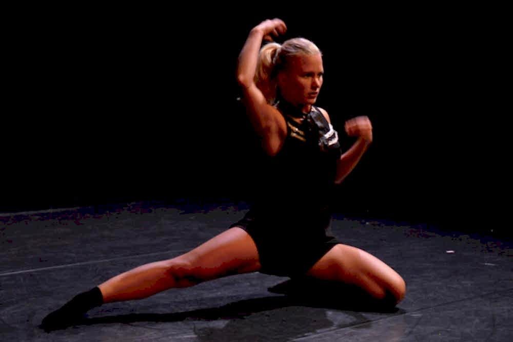 danseres op podium in zwart kostuum