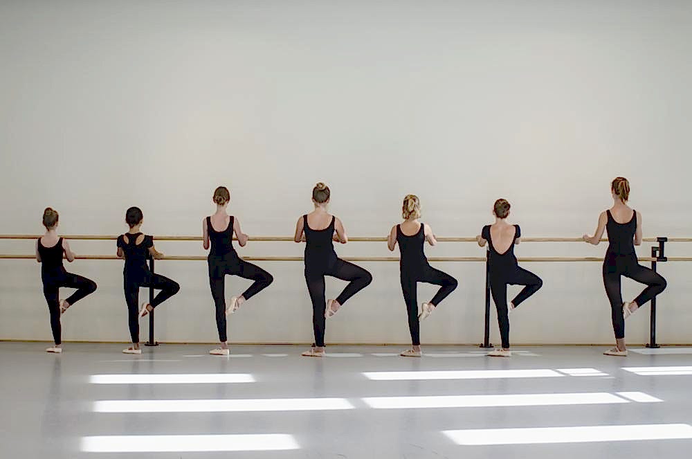 zeven kinderen op een rij in balletpositie